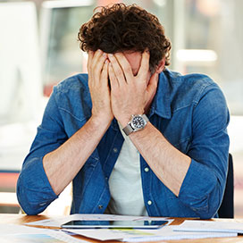 verzweifelter mann sitzt am schreibtisch