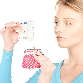 frau schaut missmutig auf einen geldschein