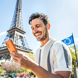 junger mann mit smartphone beim eiffelturm
