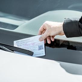 strafzettel an der frontscheibe eines autos
