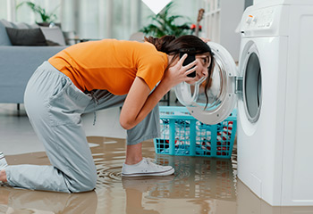frau vor kaputter waschmaschine