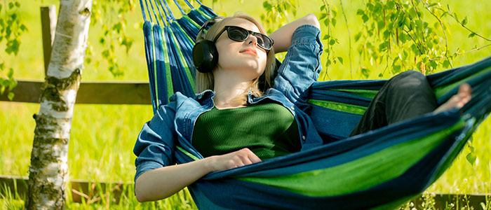 junge frau hört musik in der hängematte