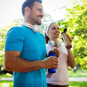 junger mann und junge frau trinken wasser nach dem Sport