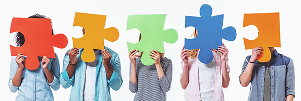 junge leute mit puzzleteilen in der hand