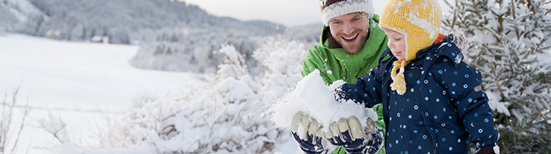 vater mit sohn im schnee