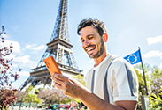 mann ist in paris im urlaub und nutzt smartphone