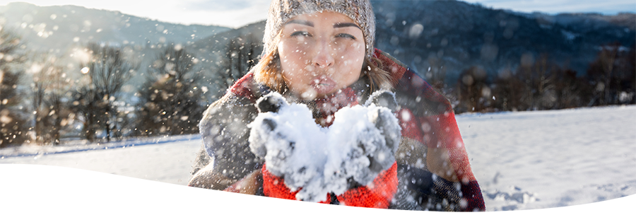 frau bl&auml;st schnee von den handschuhen
